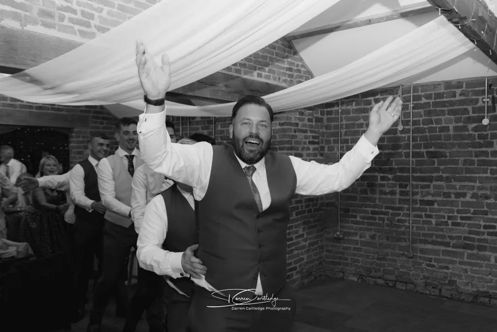 Groom leads a conga line at Yorkshire Wedding.