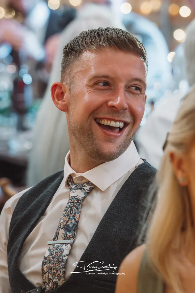 Guest laughs during speeches at Yorkshire wedding.