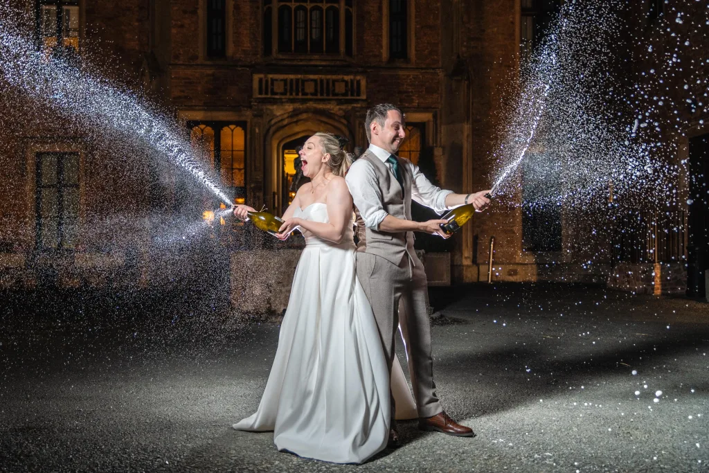 Couple spraying a bottle of bubbly during celebratory portraits.